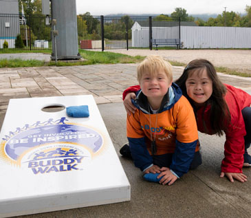 Down Syndrome Association of the Hudson Valley’s Buddy Walk 2022- Two youngsters are playing cornhole on the DSAHV Buddy Walk Cornhole set that says Get Involved, Be Inspired. 10/01/2022