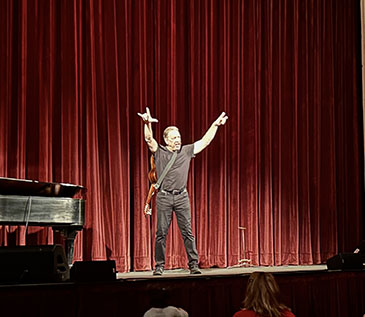 David Gonzalez performed “Cuentos- Tales from the Latino World” at the Bardavon, in partnership with Art Mid-Hudson and Dutchess County Tourism. Here, David has his arms raised with his guitar slinged across this back as he tells his stories. 3/16/23.