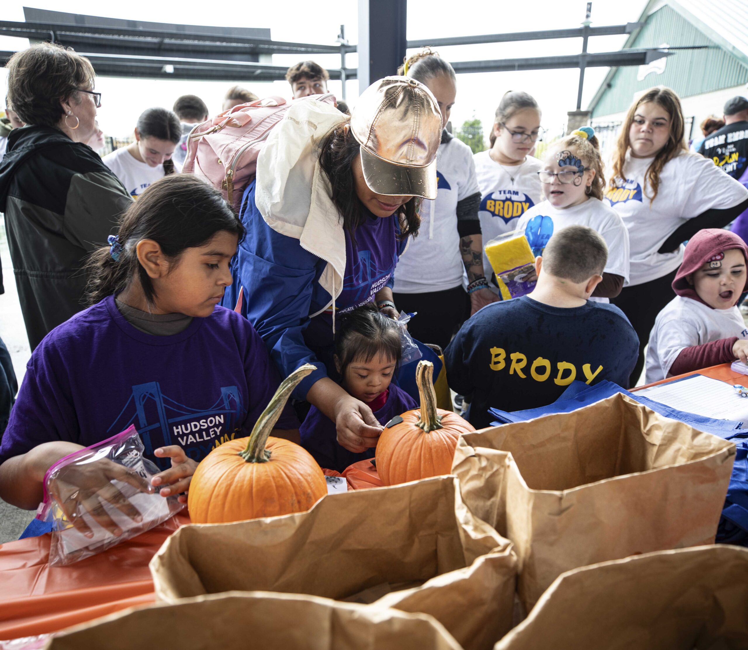 Families sit at the ThinkDIFFERENTLY table decorating their sugar pumpkins with foam stickers at the Down Syndrome Association of the Hudson Valley’s Buddy Walk on October 7, 2023 at Heritage Financial Park.