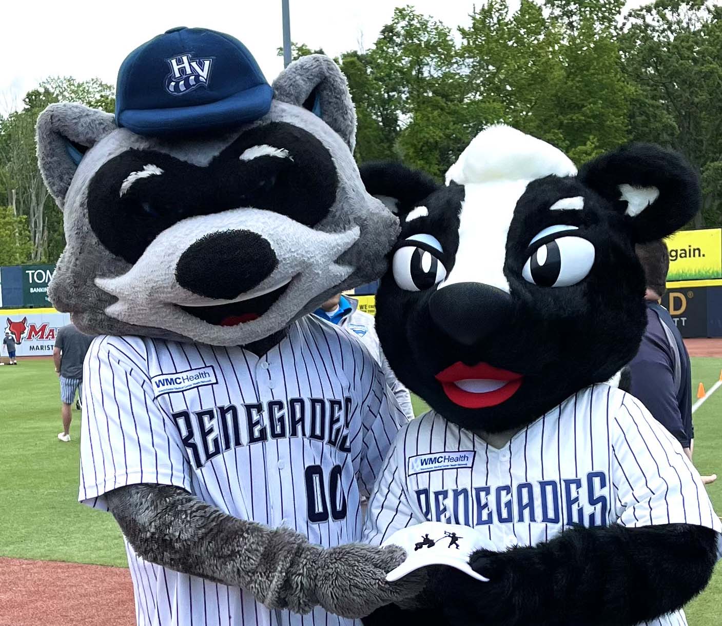 Rascal the Racoon and Rosie, his fiancé, show off a D3 Day baseball hat. The design of the hat is based on Dave Clark’s true story of Pulling Each Other Along, so it is 2 young kids, one in a Red Radio Flyer Wagon being pulled by the other youth, who is also holding a crutch in the air. Disability, Dream and Do (also known as D3 Day) at Heritage Financial Field, June 17, 2023